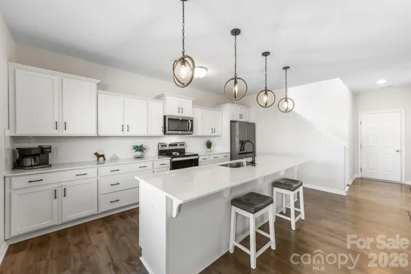 a kitchen with stainless steel appliances a stove a sink and cabinets