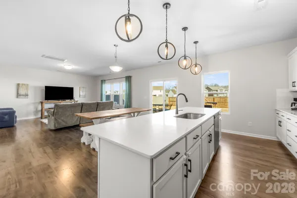 a large white kitchen with a large window and a clock on the wall