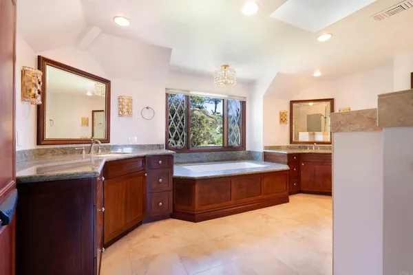 a spacious bathroom with a granite countertop sink and a mirror