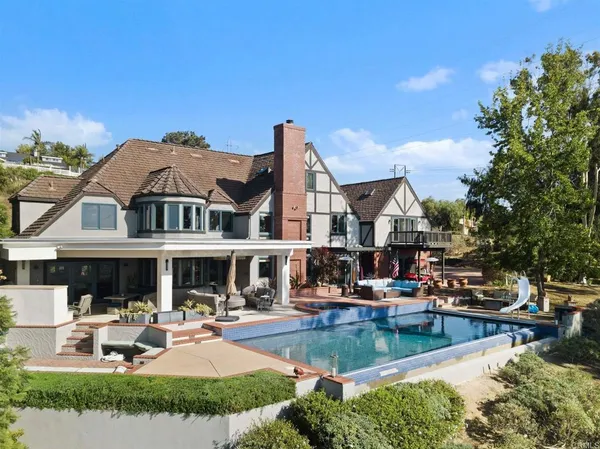 a view of a house with swimming pool and sitting area