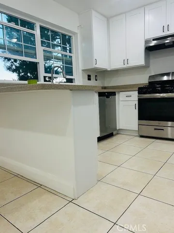 a kitchen with stainless steel appliances a stove a sink and a refrigerator