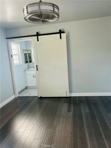 a view of room with stainless steel appliances wooden floor and window