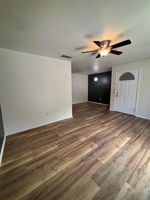 1500 Lake Shore Drive, Unit 213 Waco, TX 76708 - Photo 18 of 21 a view of a big room with wooden floor and ceiling fan