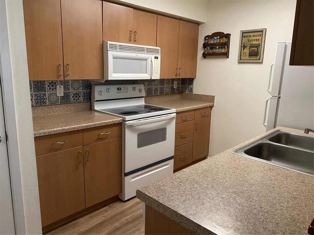 1500 Lake Shore Drive, Unit 213 Waco, TX 76708 - Photo 5 of 21 a kitchen with a sink stove and microwave
