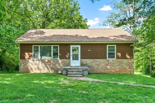a front view of house with yard and outdoor seating