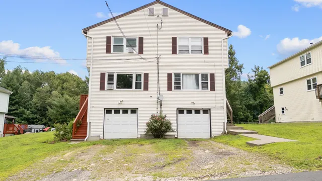 a view of a house with backyard and trees
