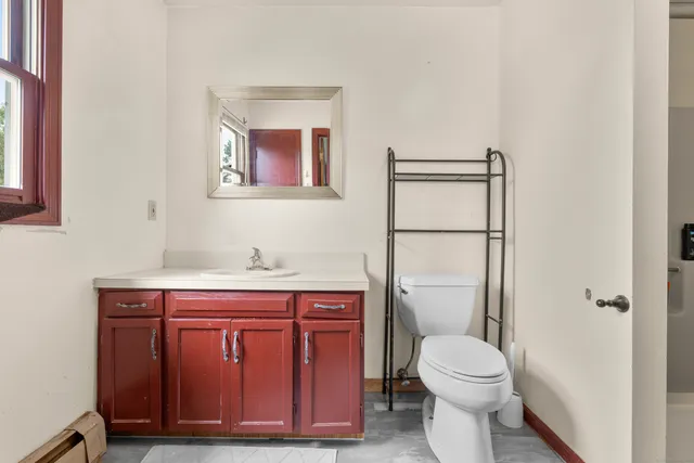 a bathroom with a toilet a sink and mirror