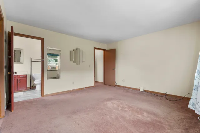 an empty room with chandelier fan