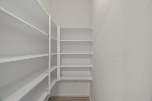 a view of walk in closet with empty racks