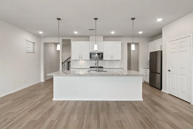 a view of kitchen with refrigerator microwave and wooden floor
