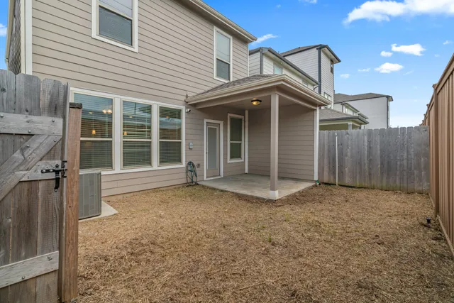 a view of a house with a large window and wooden fence
