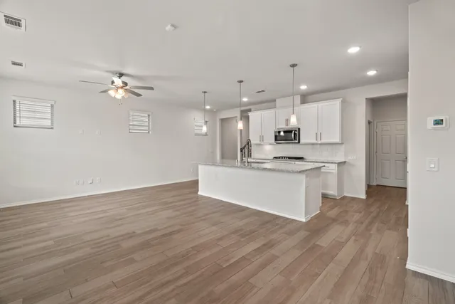an open kitchen with kitchen island white cabinets and stainless steel appliances