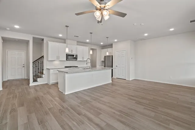 a view of kitchen with granite countertop cabinets and refrigerator