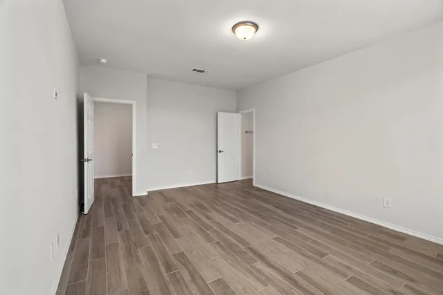 a view of an empty room with wooden floor
