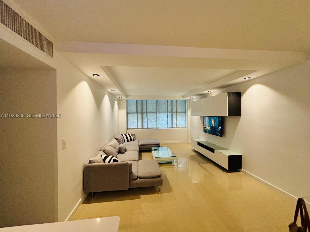 7441 Wayne Avenue, Unit 1R Miami Beach, FL 33141 - Photo 14 of 25 a living room with furniture gym equipment and a flat screen tv