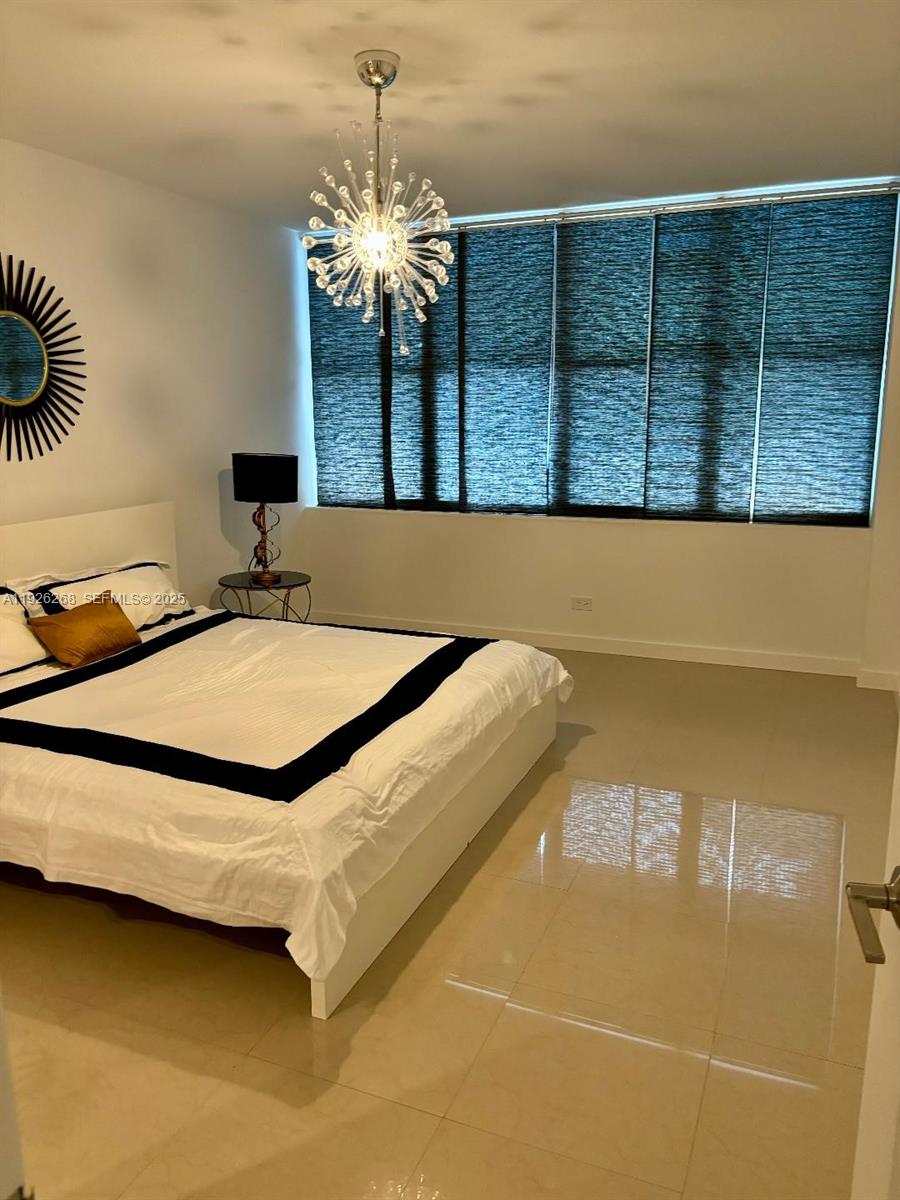 7441 Wayne Avenue, Unit 1R Miami Beach, FL 33141 - Photo 20 of 25 a spacious bathroom with a granite countertop sink a mirror and shower