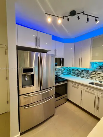a kitchen with granite countertop white cabinets and stainless steel appliances