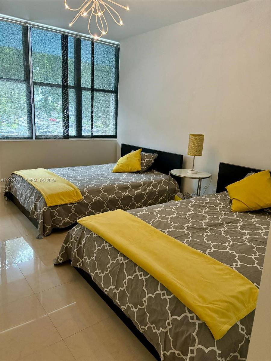 7441 Wayne Avenue, Unit 1R Miami Beach, FL 33141 - Photo 24 of 25 a bedroom with two beds and a large window