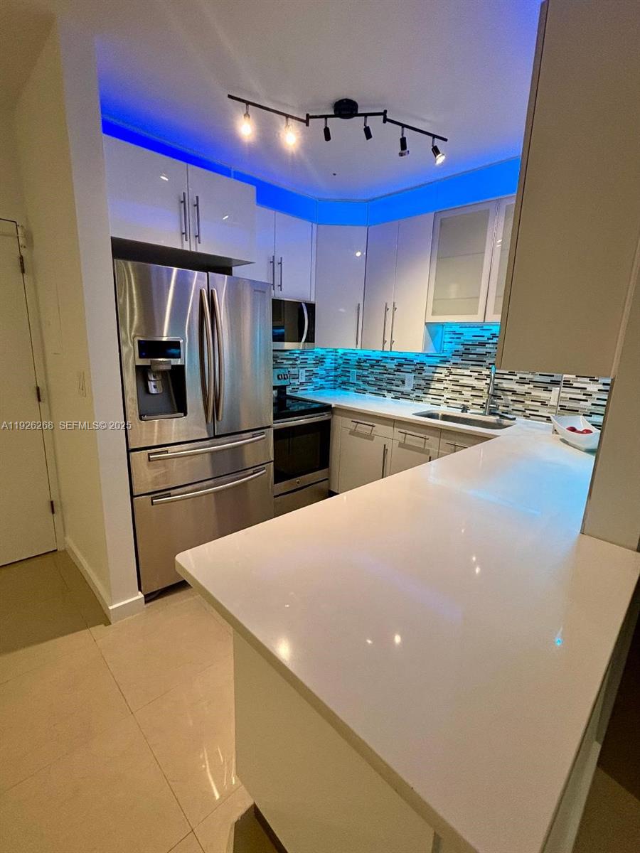 7441 Wayne Avenue, Unit 1R Miami Beach, FL 33141 - Photo 4 of 25 a kitchen with stainless steel appliances a refrigerator and a stove
