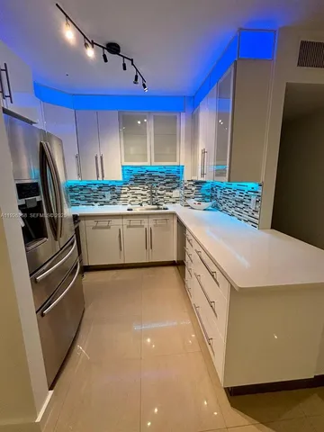 a kitchen with stainless steel appliances a sink and a refrigerator
