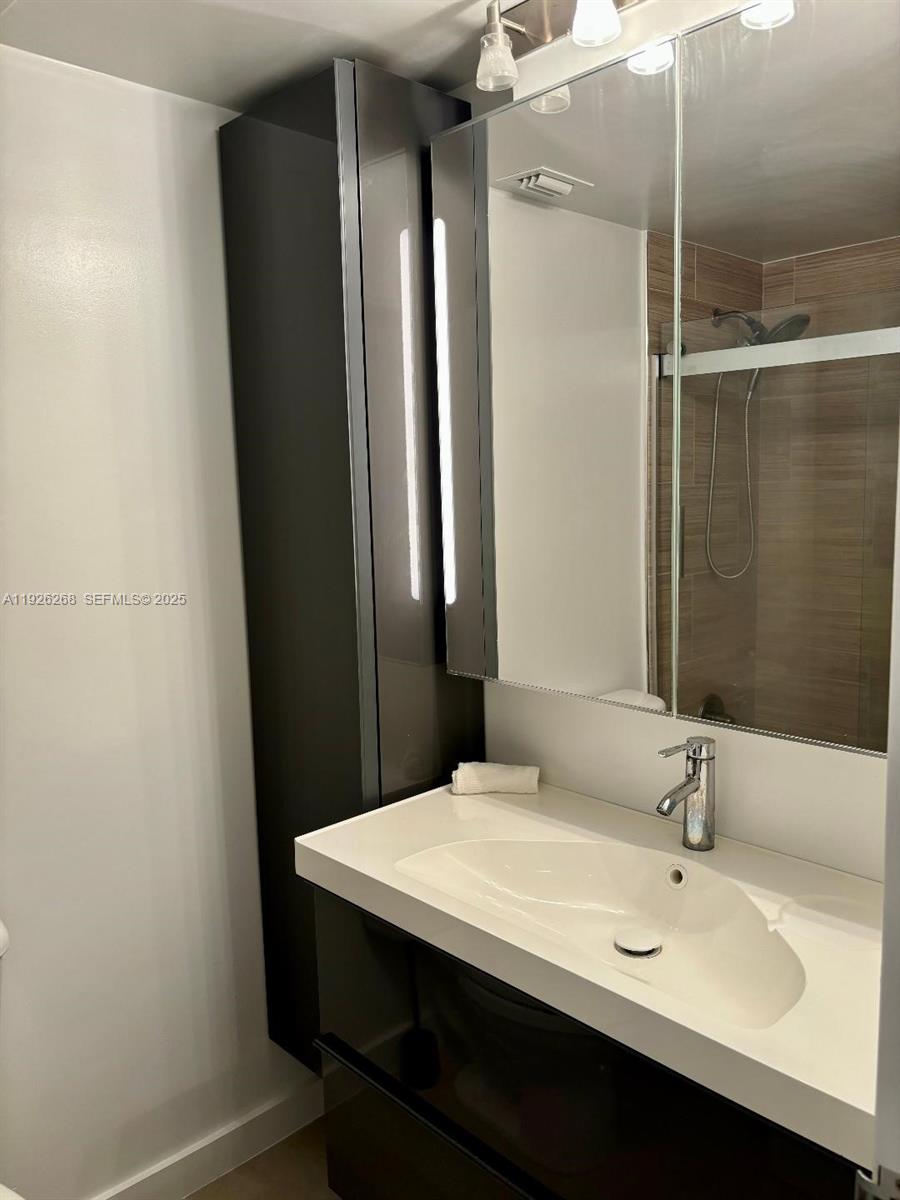 7441 Wayne Avenue, Unit 1R Miami Beach, FL 33141 - Photo 7 of 25 a bathroom with a sink and a mirror