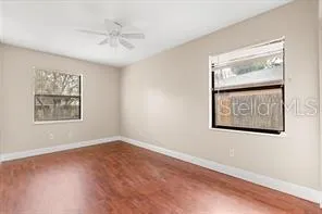 an empty room with windows and fan