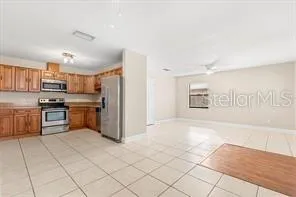 a kitchen with granite countertop a refrigerator and a stove top oven