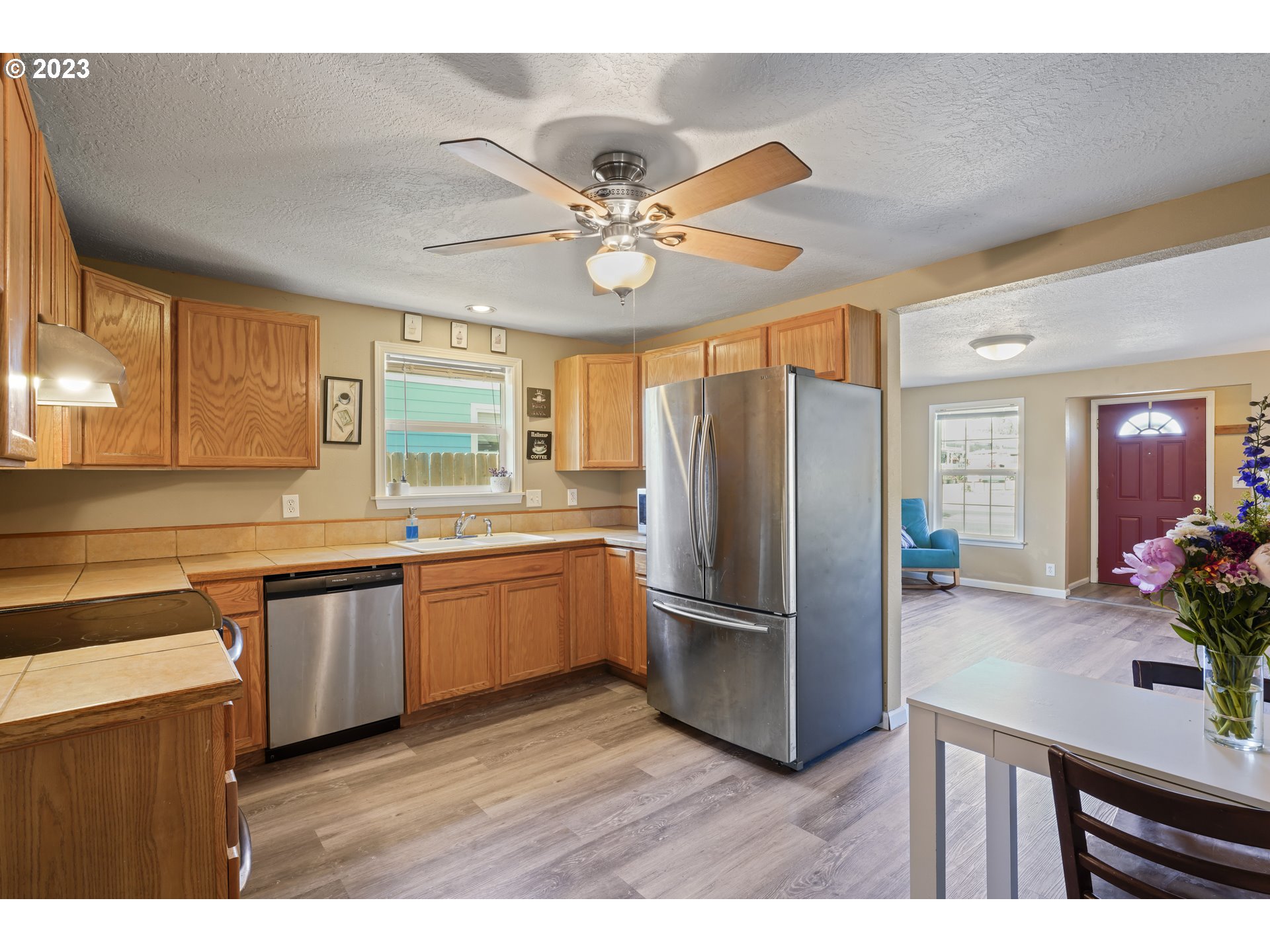 760 28th Street Springfield, OR 97477 - Photo 10 of 30 a kitchen with stainless steel appliances kitchen island granite countertop a refrigerator a sink dishwasher and a stove with wooden floor