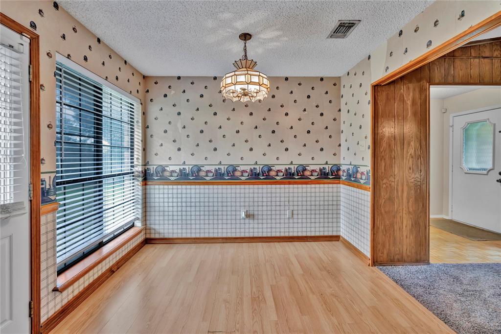 108 Prairie Creek Road Red Oak, TX 75154 - Photo 6 of 19 Spacious room featuring wood-finish flooring, a large window with blinds, and a decorative ceiling light fixture