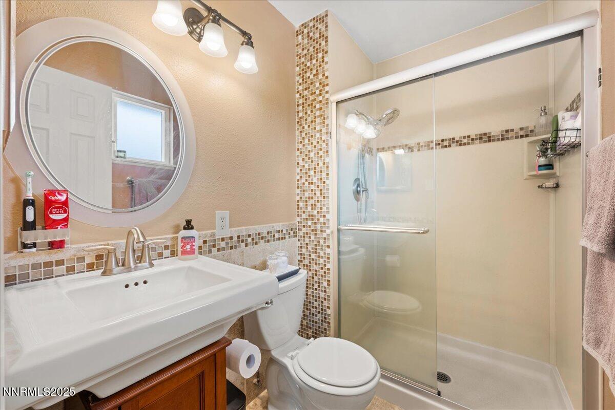 610 Akard Circle Reno, NV 89503 - Photo 14 of 28 a bathroom with a sink a mirror a toilet and shower