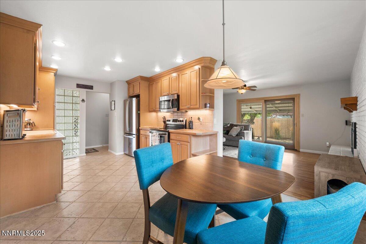 610 Akard Circle Reno, NV 89503 - Photo 8 of 28 a kitchen with stainless steel appliances kitchen island granite countertop a dining table chairs and a refrigerator