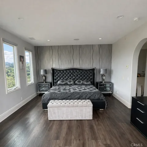 a bedroom with a bed window and a table in it