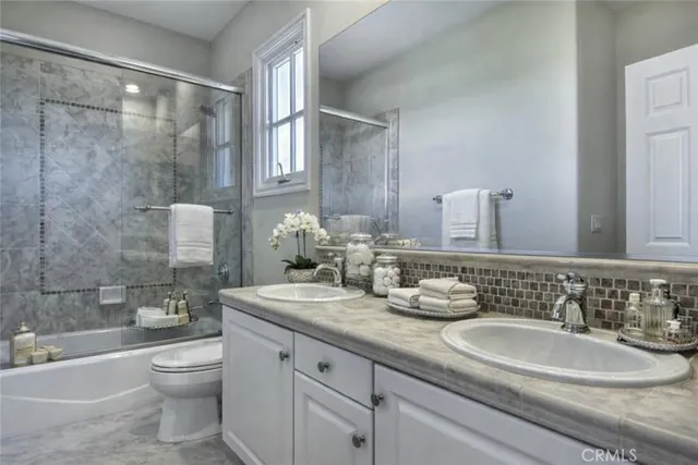 a bathroom with a double vanity sink toilet and a bathtub