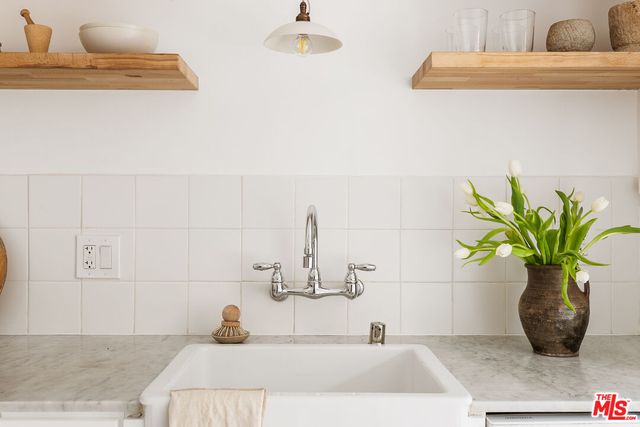 a bathroom with a sink a vanity and a potted plant
