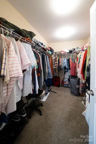 a view of walk in closet with clothes and shoes