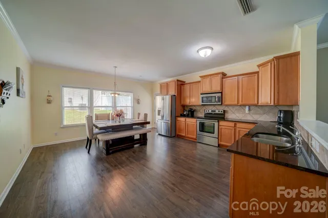 a kitchen with sink a refrigerator and wooden cabinets