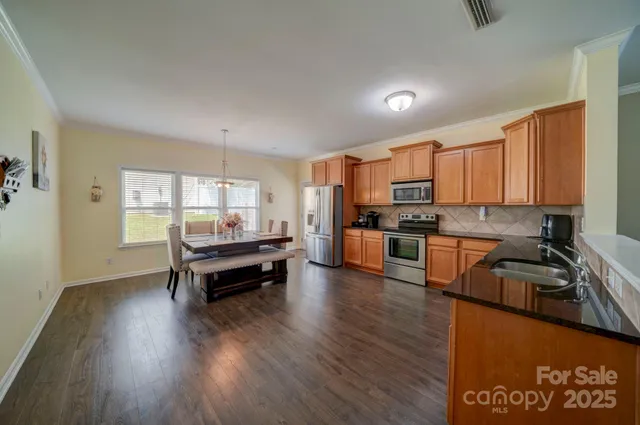 a kitchen with sink a refrigerator and wooden cabinets