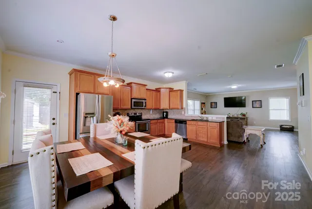 a living room with furniture kitchen view and a wooden floor