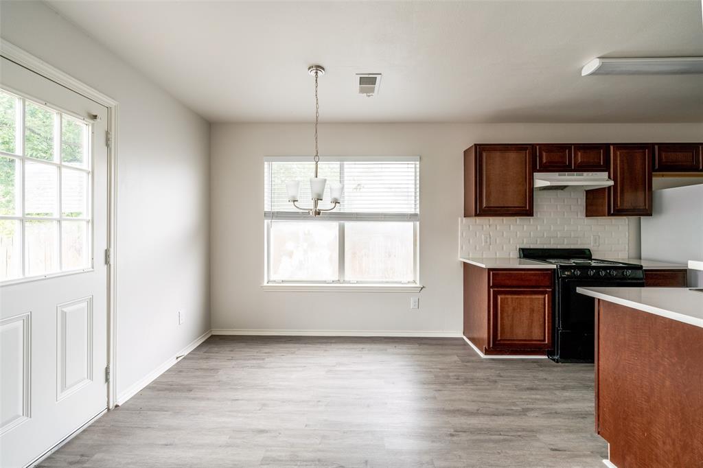 9927 Bilbrook Place, Unit B Austin, TX 78748 - Photo 3 of 13 Kitchen with black gas range, light countertops, tasteful backsplash, light wood-style flooring, and a chandelier