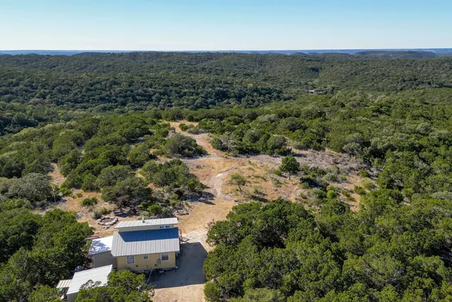 an aerial view of house with yard and mountain view in back