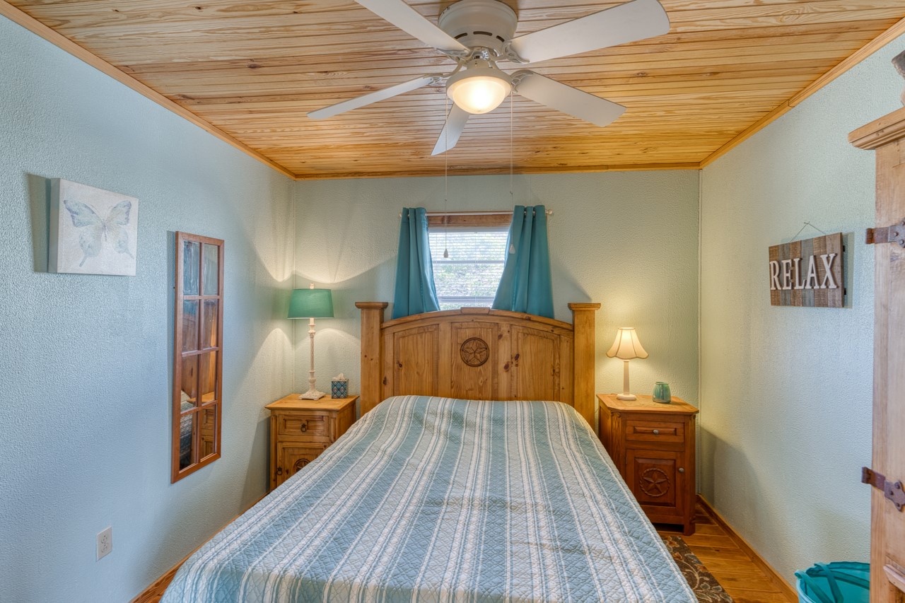 509 Pinon Loop East Camp Wood, TX 78833 - Photo 10 of 24 a bedroom with a bed and wooden floor