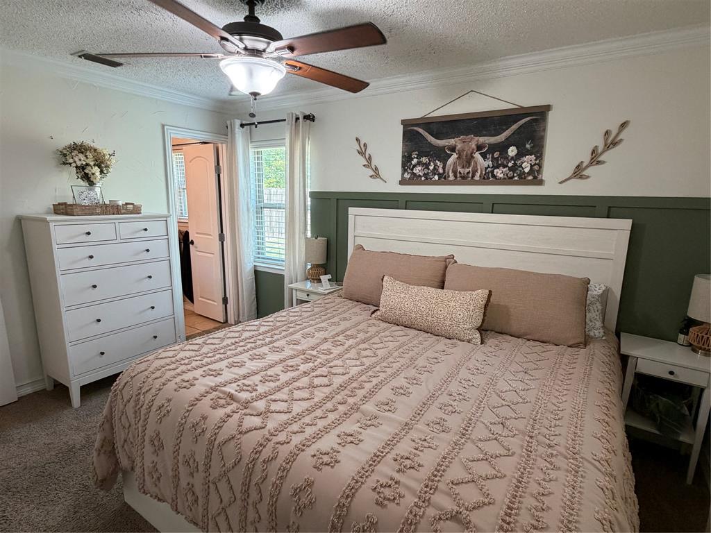 806 Glen Key Street Denison, TX 75020 - Photo 13 of 27 a bedroom with a large bed and a ceiling fan
