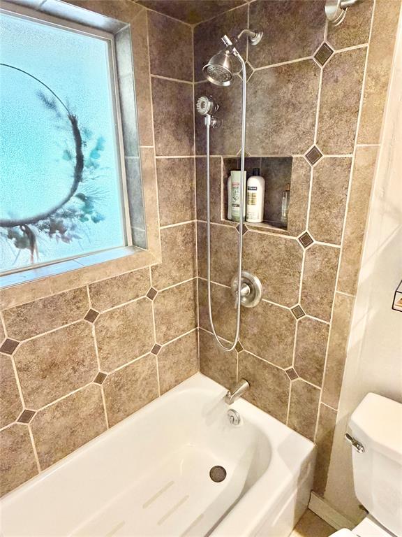 806 Glen Key Street Denison, TX 75020 - Photo 19 of 27 a bathroom with a bathtub and a toilet