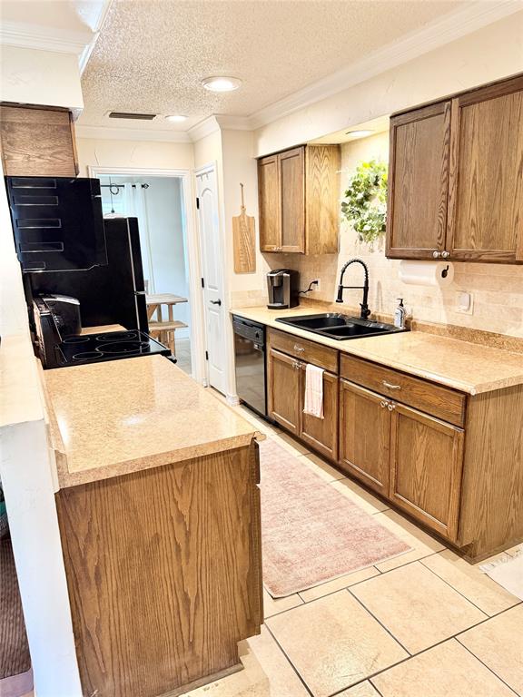 806 Glen Key Street Denison, TX 75020 - Photo 6 of 27 a kitchen with stainless steel appliances a sink a stove a microwave a counter top space and cabinets