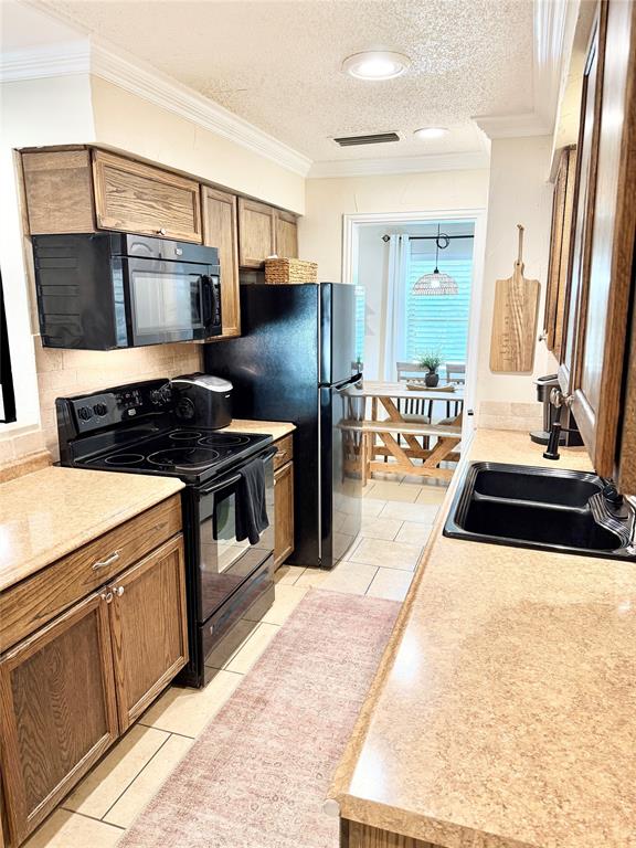 806 Glen Key Street Denison, TX 75020 - Photo 7 of 27 a kitchen with stainless steel appliances granite countertop a stove a sink and a microwave