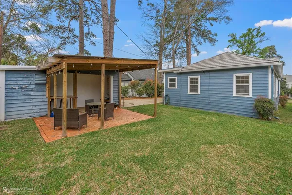 a view of a chair and table in backyard of the house