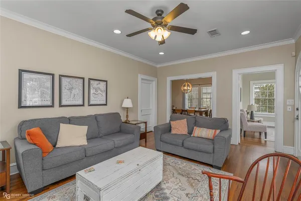 a living room with furniture a ceiling fan and a window