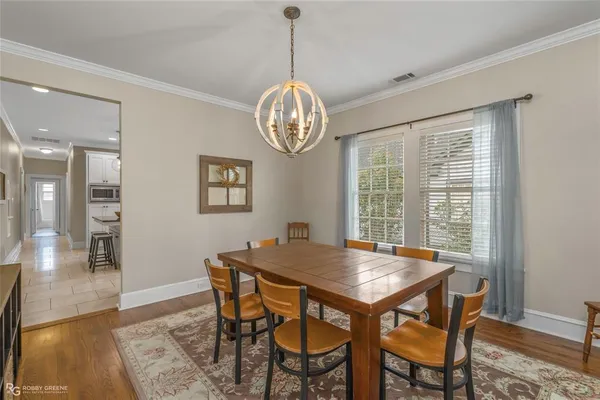 a view of a dining room with furniture wooden floor and a chandelier