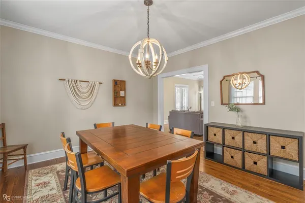 a view of a dining room with furniture a chandelier and wooden floor