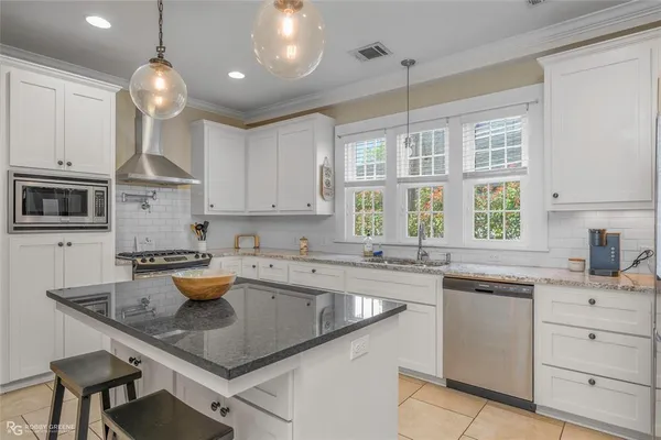 a kitchen with lot of cabinets a sink a window and stainless steel appliances